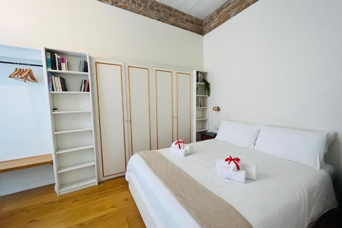Un dormitorio con una cama grande, un armario con varias puertas y una estantería.