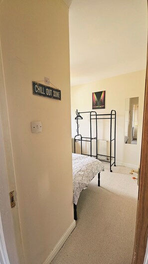 A bedroom with a bunk bed, a 'CHILL OUT ZONE' sign, a radiator, and a door leading to another room. - Self Check-in, 2 Bedroom peaceful home, 5 min from  Beeston station, Nottingham (Beeston)