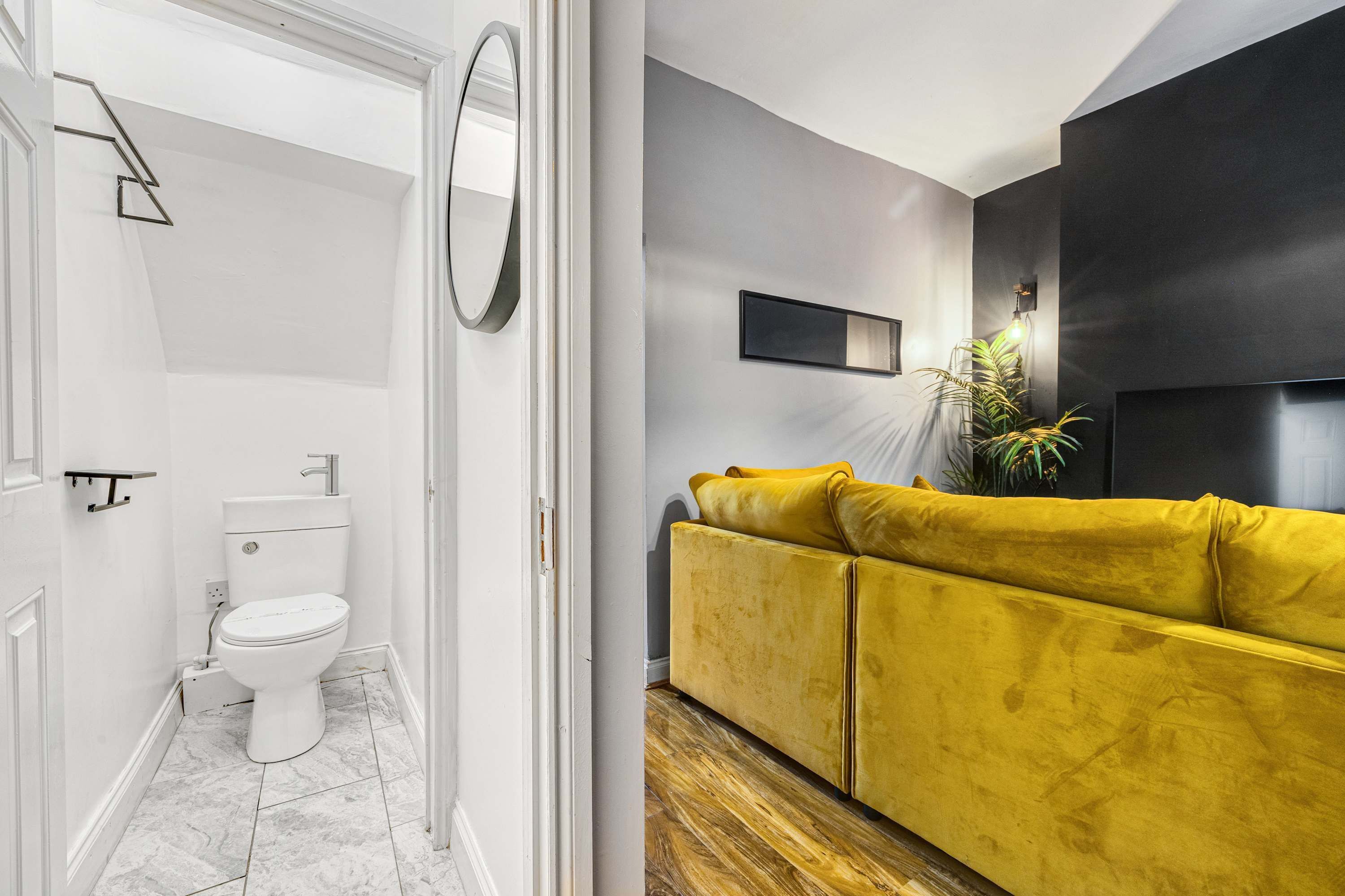 Ein Badezimmer mit Toilette, Spiegel und einem gelben Sofa in modernem Design.