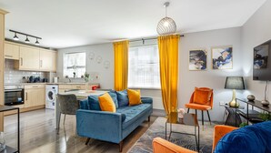 A modern apartment with a kitchen, dining area, and living room. - Trafford Centre Cityscape Hideaway Free Parking (Manchester)