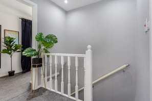 A staircase with white balusters, a handrail, and a potted plant on the left. - Family Haven 5 min to City Centre 2 Free Parking (Salford)