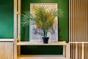 A potted plant on a shelf with a framed artwork in the background. - 2 Free Park Space The Quays- Sleeps 8 2 Ensuites (Salford)