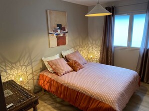 A bedroom with a large bed, a bedside table, a lamp, and a window with curtains. - Jungle - Air-conditioned 4* apartment with terrace and mountain views (DRUMETTAZ CLARAFOND)