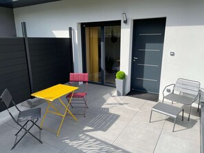 A patio with a yellow table, two chairs, a red bench, and a potted plant. - Yellow Cab - Air-conditioned 3* apartment with terrace and mountain views (DRUMETTAZ CLARAFOND)