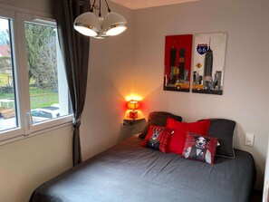A bedroom with a bed, a lamp, a window, and a wall with a traffic sign. - Yellow Cab - Air-conditioned 3* apartment with terrace and mountain views (DRUMETTAZ CLARAFOND)