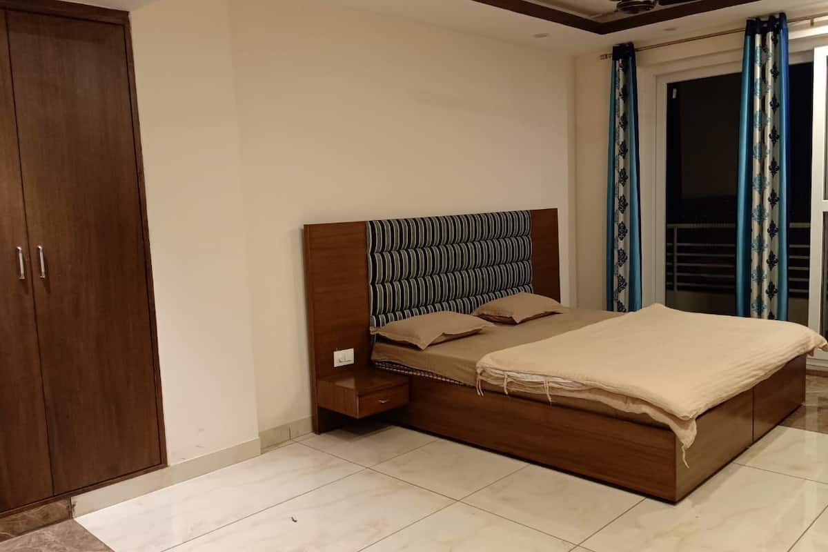 Un dormitorio con cama, mesita de noche, armario y ventilador de techo.