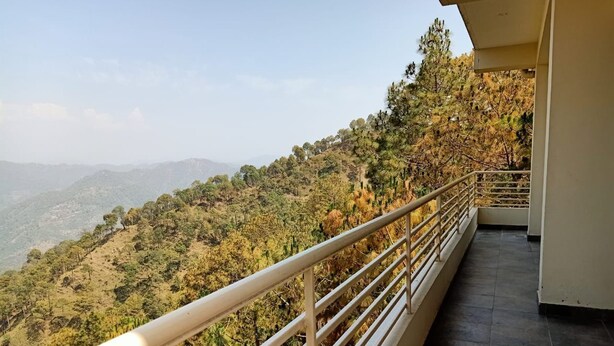 A balcony with a metal railing overlooking a mountainous landscape. - Pine Peak Kasauli (Kasauli)