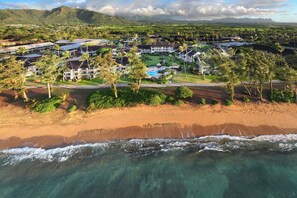A coastal resort with multiple buildings, a swimming pool, and a beachfront.