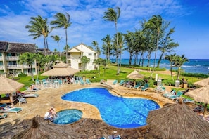 Ein Resort mit großem Pool, Liegestühlen und Blick auf den Ozean.