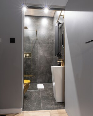 Un baño moderno con ducha, inodoro y lavamanos.