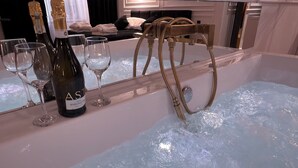 A bar area with a bottle of Ast wine, glasses, and a gold bar stool. - Apartament z Jacuzzi Kraków SHINE Starowiślna (Kraków)