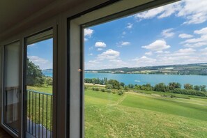 Un balcon avec vue sur un lac et les environs.