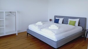 A bedroom with a bed, a wardrobe, and a hanging light fixture.