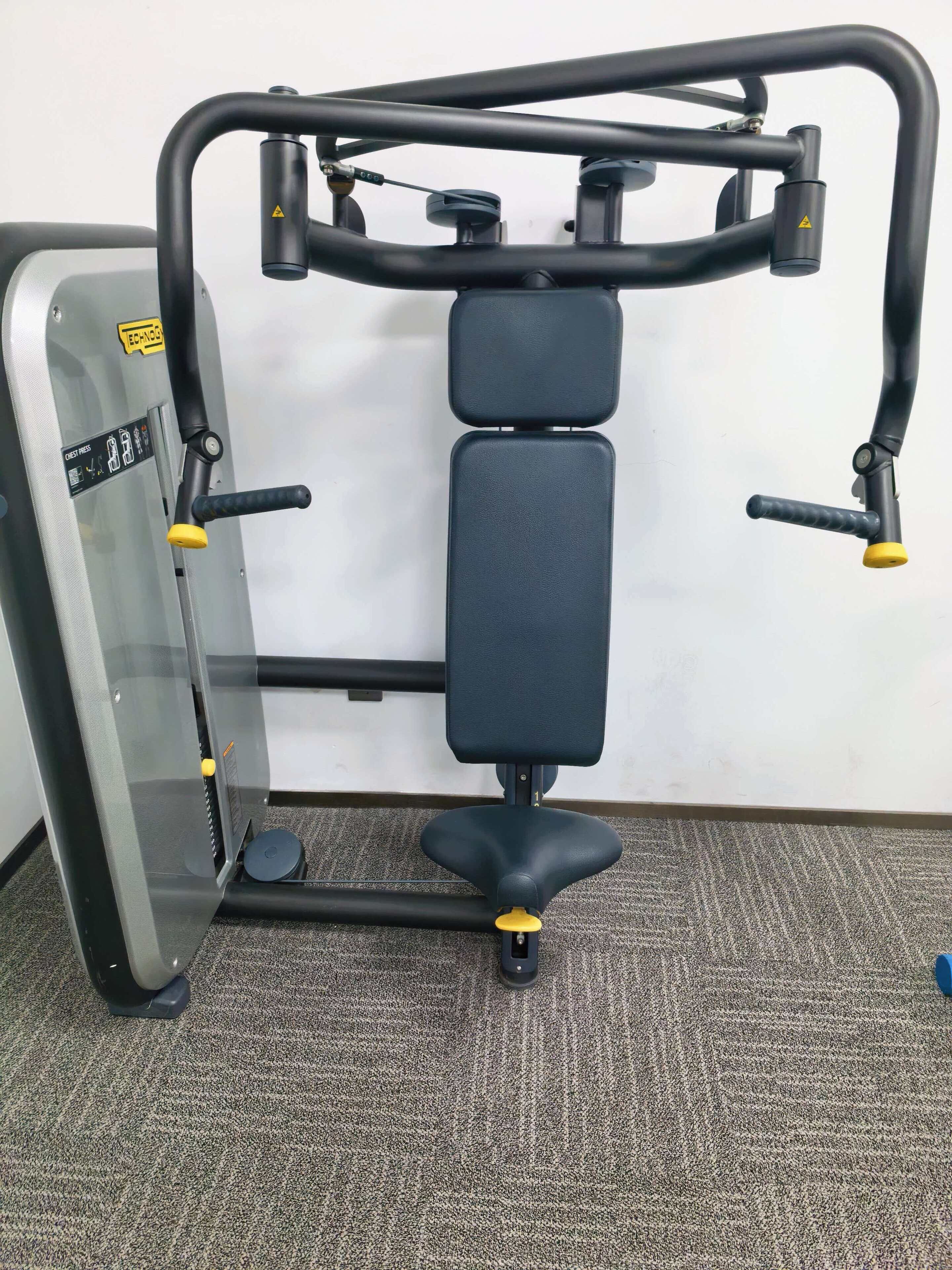 A gym with a bench press, a chest press machine, and a pull-up bar.
