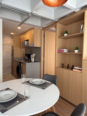 Eine moderne Küche mit Holzschränken, einem Backofen und einer Mikrowelle.