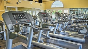 Ein Fitnessstudio mit mehreren Laufbändern, Krafttrainingsgeräten und Cardio-Ausrüstung.