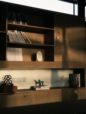 Ein Bücherregal aus Holz mit Büchern, einer Uhr und dekorativen Gegenständen.