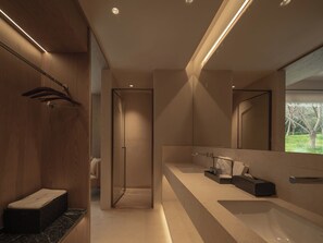 Un baño moderno con un espejo grande, una bañera y una zona de ducha.