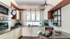 A modern kitchen with built-in appliances, a central island, and a window providing natural light. - Riflesso del Lago - by MyHomeInComo (Menaggio)