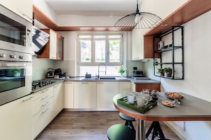 Eine moderne Küche mit eingebauten Geräten, einer zentralen Kochinsel und einem Fenster für natürliches Licht.