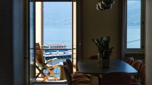 A dining area with a view of a body of water and a boat. - Riflesso del Lago - by MyHomeInComo (Menaggio)
