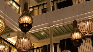 Un atrium à plusieurs niveaux, agrémenté de luminaires décoratifs suspendus et doté d’une balustrade.