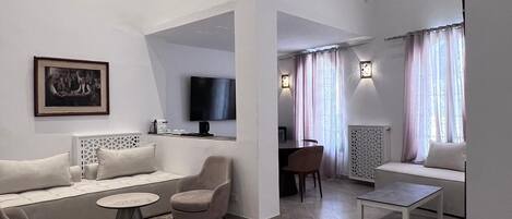 Una sala de estar moderna con un juego de sofá, una mesa de centro y un televisor montado en la pared.