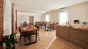 A modern dining area with wooden tables and chairs, a buffet counter, and a brick wall. - Brussa Horse Oasi (Caorle)