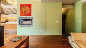 Uma sala de estar moderna com lareira, televisão e sofá.