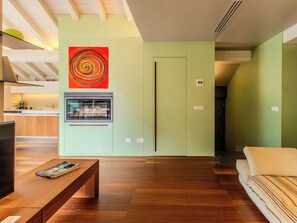 Ein modernes Wohnzimmer mit Kamin, Fernseher und Sofa.