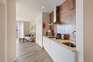 Una cucina moderna con un lavandino in acciaio inossidabile, un forno a microonde e un bollitore.