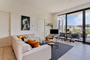 Una sala de estar moderna con un sofá, una mesa de centro y un televisor de pantalla plana.