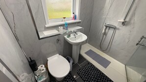 A small bathroom with a toilet, sink, and shower. - Erskine - House - Sleeps 4 - Parking - River Side (Erskine)