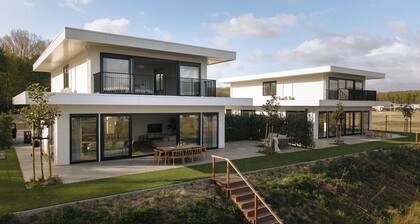 Luxury 16-person villa by the water. Two spacious homes with hot tubs, saunas, and a private jetty. Perfect for families and groups of friends!