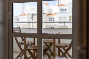 Ein Balkon mit Holzmöbeln und Blick auf Gebäude.