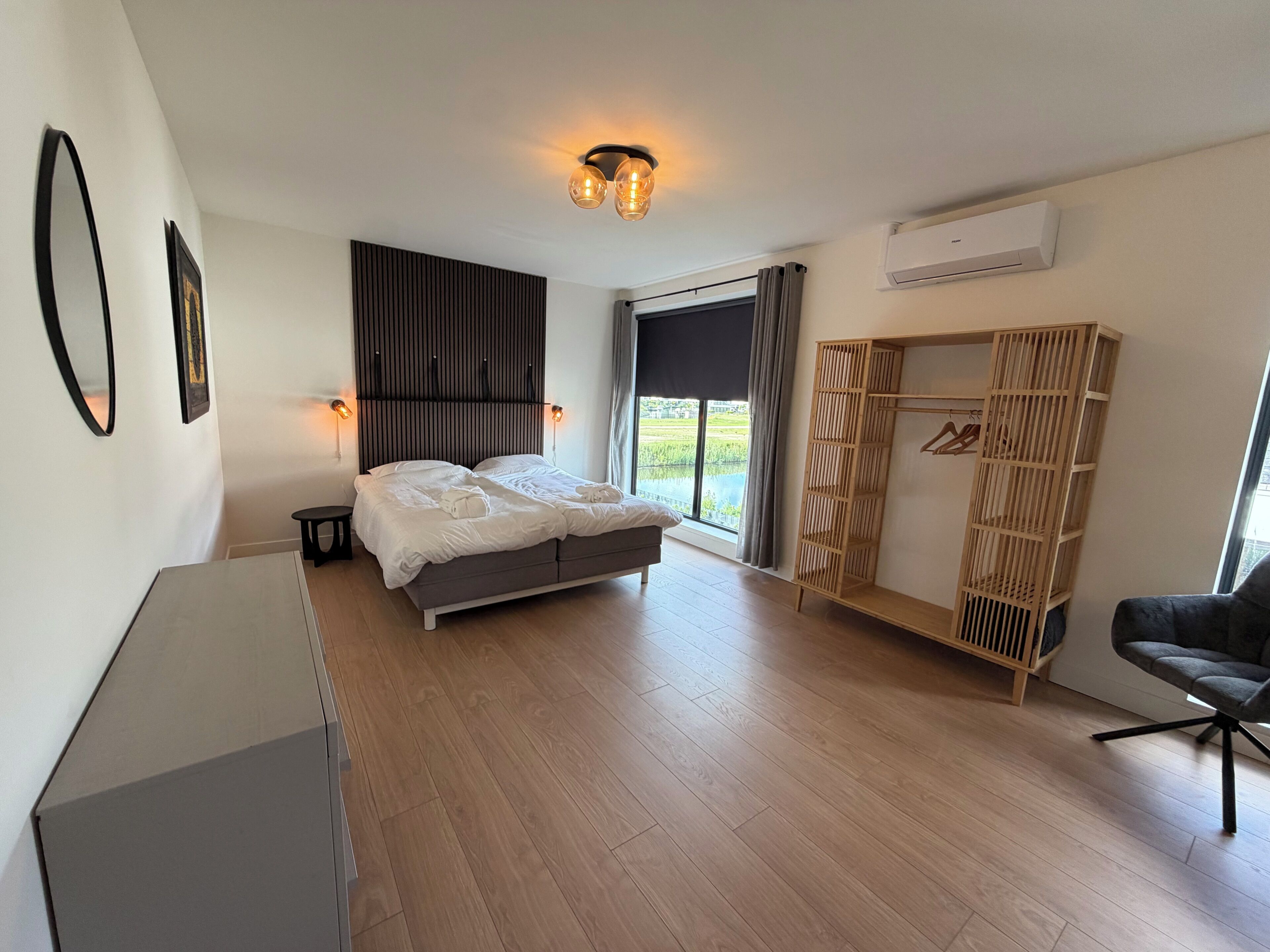 Une chambre à coucher moderne avec un lit, des tables de chevet, une armoire et une chaise.