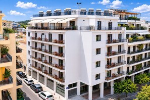 A multi-story hotel with balconies, outdoor seating, and a rooftop terrace. - LIV - Upscale Athenian Apartment 2A (Athens)