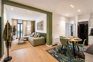 Eine moderne Wohnung mit Wohnbereich, Essplatz und Küchenzeile.