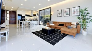 A modern living room with a sofa, coffee table, and artwork on the wall. - Pearl of Madeira by Atlantic Holiday (Calheta)