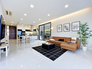 A modern living room with a sofa, coffee table, and artwork on the wall. - Pearl of Madeira by Atlantic Holiday (Calheta)