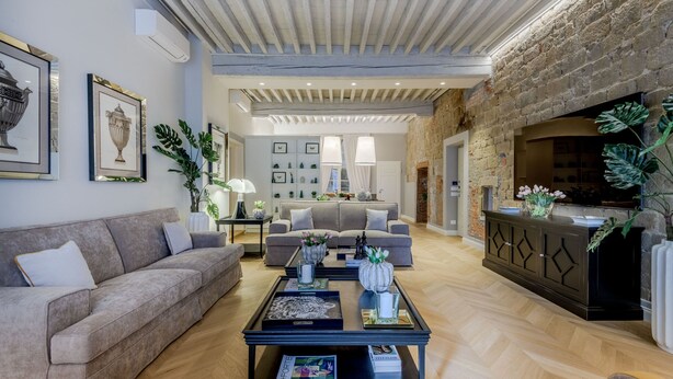 A modern living room with a sofa, coffee table, and fireplace. - The Gilded Residence (Lucca)