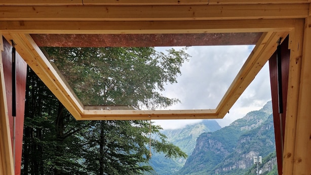 A room with a bed, a view of mountains, and a wooden ceiling. - Glamping Alpe Campo Rimasco (Rimasco)