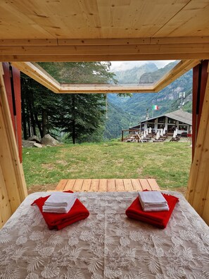 A room with a wooden ceiling and a view of a mountain landscape. - Glamping Alpe Campo Rimasco (Rimasco)