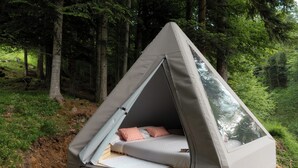 A tented accommodation with a bed, a window, and a view of the forest. - Glamping Alpe Campo Rimasco (Rimasco)