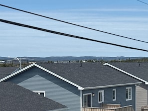 A residential area with houses featuring gabled roofs and a clear sky. - A cozy haven at the heart of the city and a minute drive to the airport (St. John's)