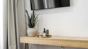 Une étagère en bois avec une plante en pot, une bouteille de vin et des verres.