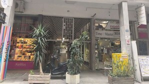 Une devanture de magasin avec une enseigne indiquant « TOA EYA » et une boutique à l’intérieur nommée « Time Master RH ».