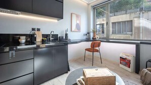 Una cocina moderna con armarios oscuros, horno empotrado y un amplio ventanal con vistas al exterior.