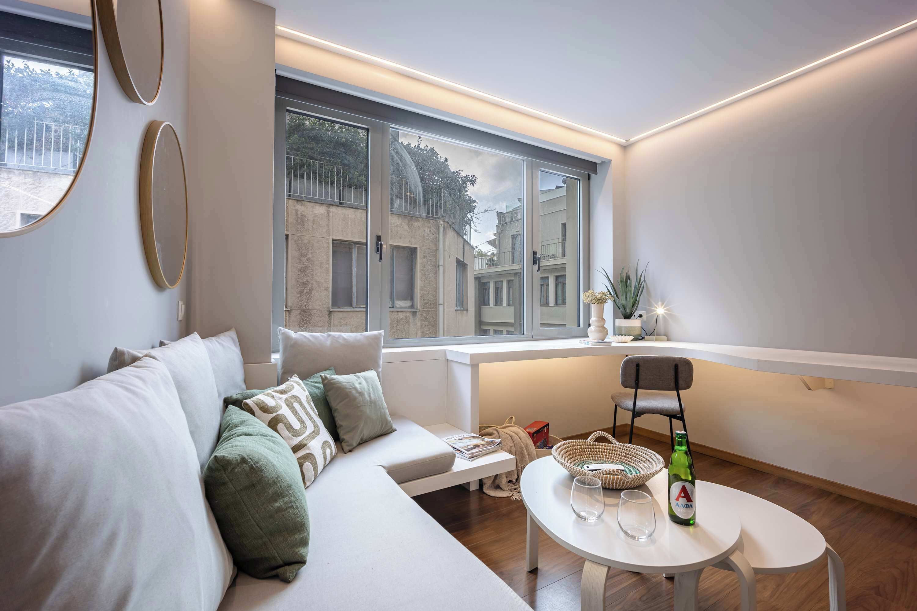 Sala de estar moderna com um sofá, uma mesa e uma janela com vista para a rua.
