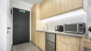 A modern kitchen with wooden cabinets, a stainless steel microwave, a coffee maker, and a dishwasher. - Chic Studio | Syntagma | Worn Bldg Entrance (Athens)